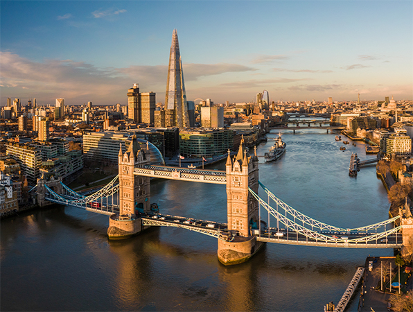 Aerial view looking over London and the River Thames, with Tower Bridge in the foreground.