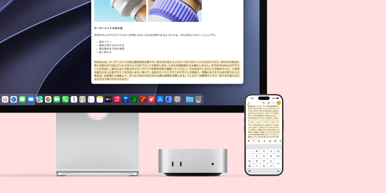 Studio Displayの下に収納されたMac miniの前面。デバイスとディスプレイの右側にiPhoneが置かれている。iPhoneの画面の上部でクリップ、コピー、ペースト、自動入力のコマンドとともに選択されたテキストが、ディスプレイ上でハイライトされているテキストと一致しており、ユニバーサルクリップボード機能を示している