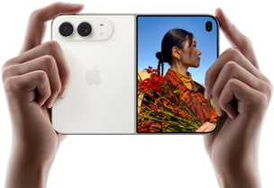 „iPhone Duo“, žvaigždžių baltos spalvos, horizontalioje padėtyje, atlenktas, kairiajame skydelyje matomos 48 MP „Dual Fusion“ galinės kameros, dešiniajame skydelyje matomas žmogus, kurio nuotrauka daroma iš išorinio ekrano, fotografuojamas asmuo gali matyti savo veidą, kol daroma nuotrauka naudojant „Duo Preview“