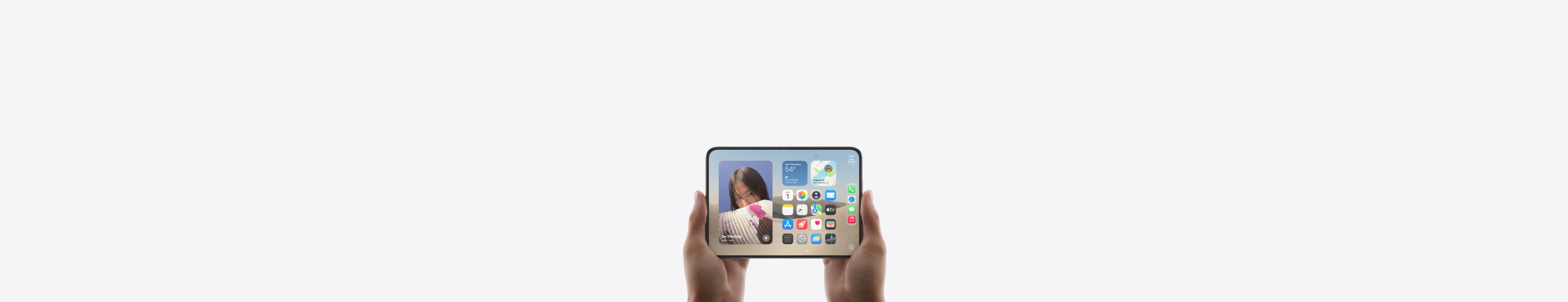 iPhone Duo, Star White color, held by a hand in closed position, outer display shown, iOS home screen with apps and widgets.