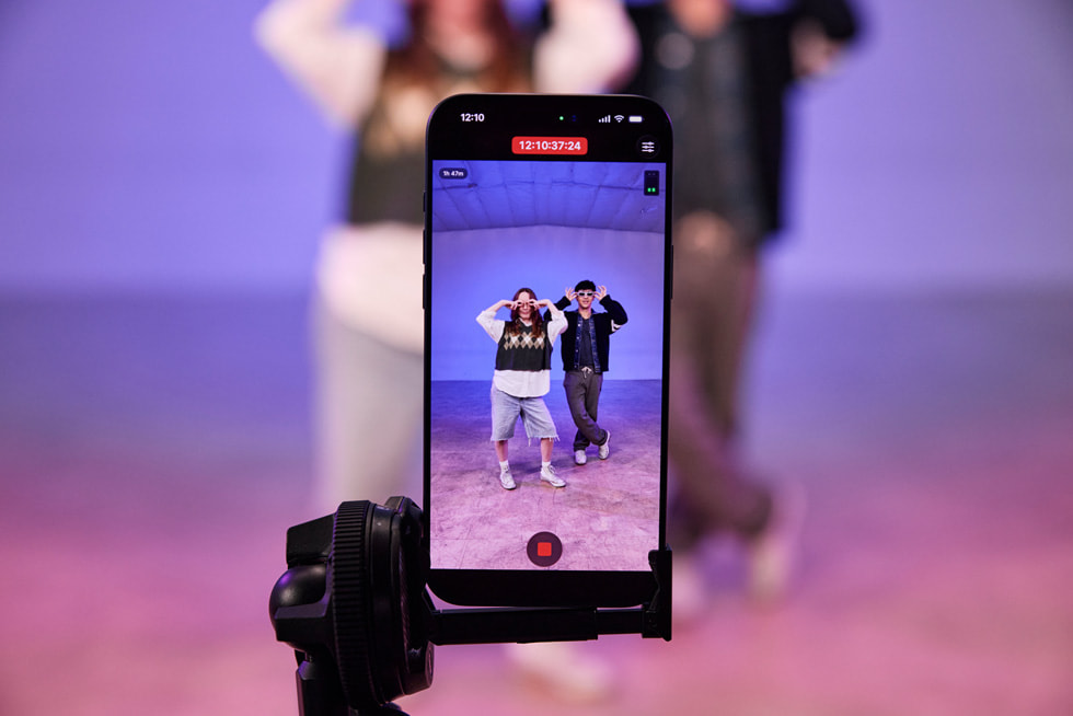 A close-up on an iPhone 17 Pro Max on a stand shows a live recording of Kyle Hanagami and a dancer showing off moves in a studio.