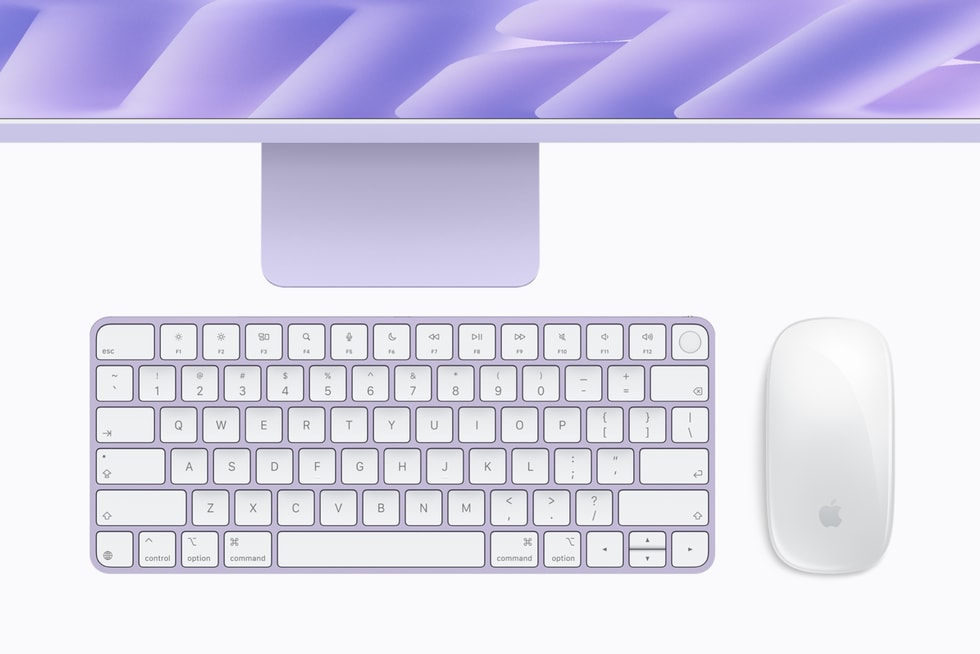 Um teclado e um mouse em cores coordenadas estão posicionados abaixo do iMac roxo com M6.