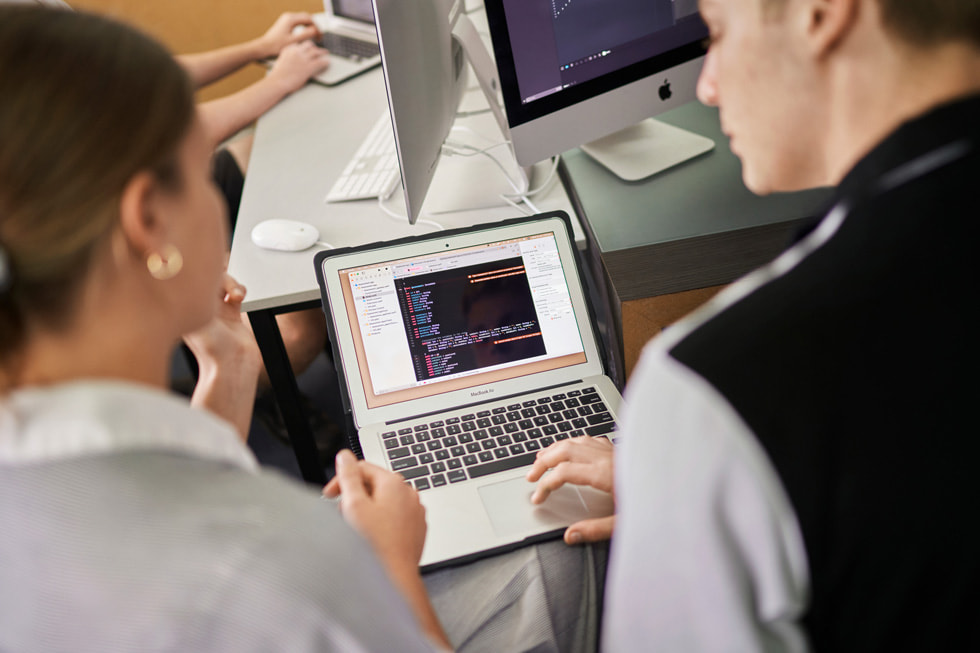 Una estudiante de Siena Catholic College y su instructor revisan código en una MacBook Air.