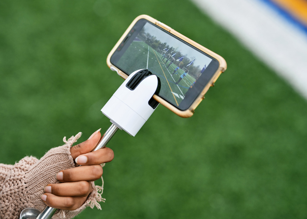 Estudiantes de la preparatoria New Rochelle usan el iPad para grabar un video de los abanderados en el campo de deportes.
