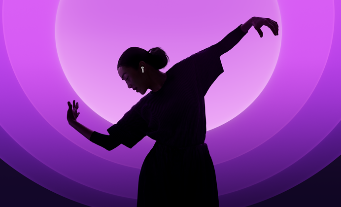 Tancujúci človek s nasadenými slúchadlami AirPods 5 na pestrofarebnom pozadí