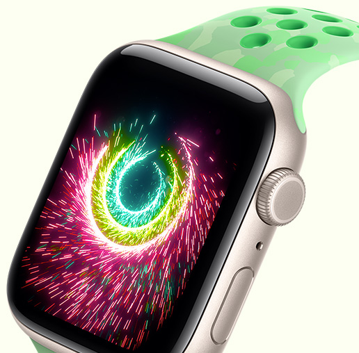 Apple Watch SE 3, écran affichant les anneaux Activité scintillant comme un feu d’artifice, boîtier en aluminium, finition lumière stellaire, associée à un Bracelet Sport Nike, vert étincelle (vert menthe, avec motif subtil de formes grises et perforations circulaires)