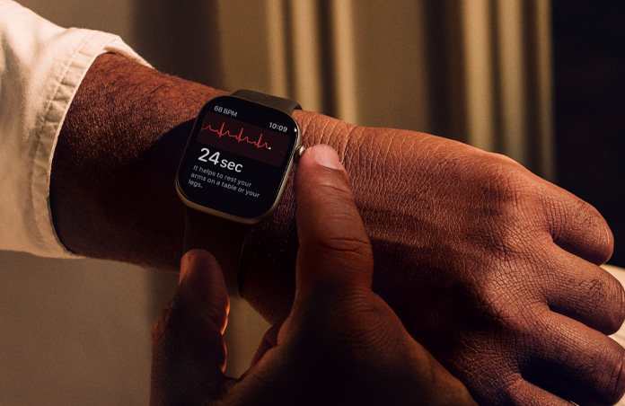 A person presses and holds Digital Crown on Apple Watch Series 11 to measure heart health in ECG app