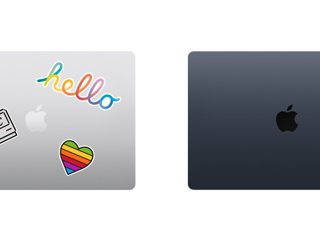 Vue du dessus de deux portables Mac refermés, dont un avec des autocollants.