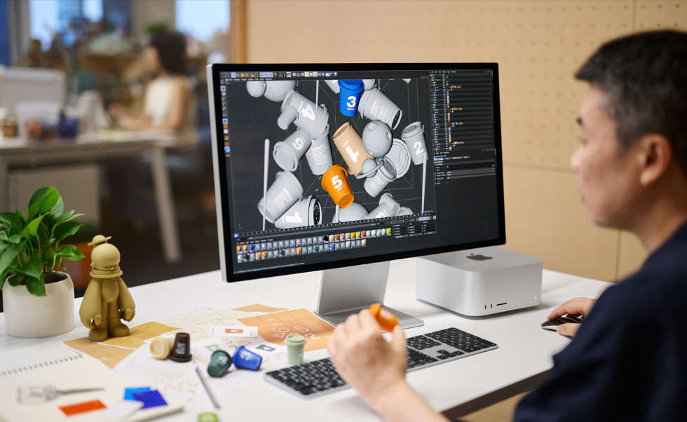 Bir tasarımcı Mac’i kullanarak 3D render alıyor.