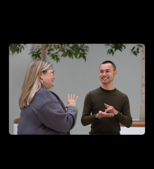 A man and a woman converse together in sign language.