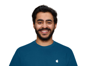 Apple Store 스페셜리스가 미소짓고 있는 모습, 파란색 Apple 셔츠를 입고 있습니다