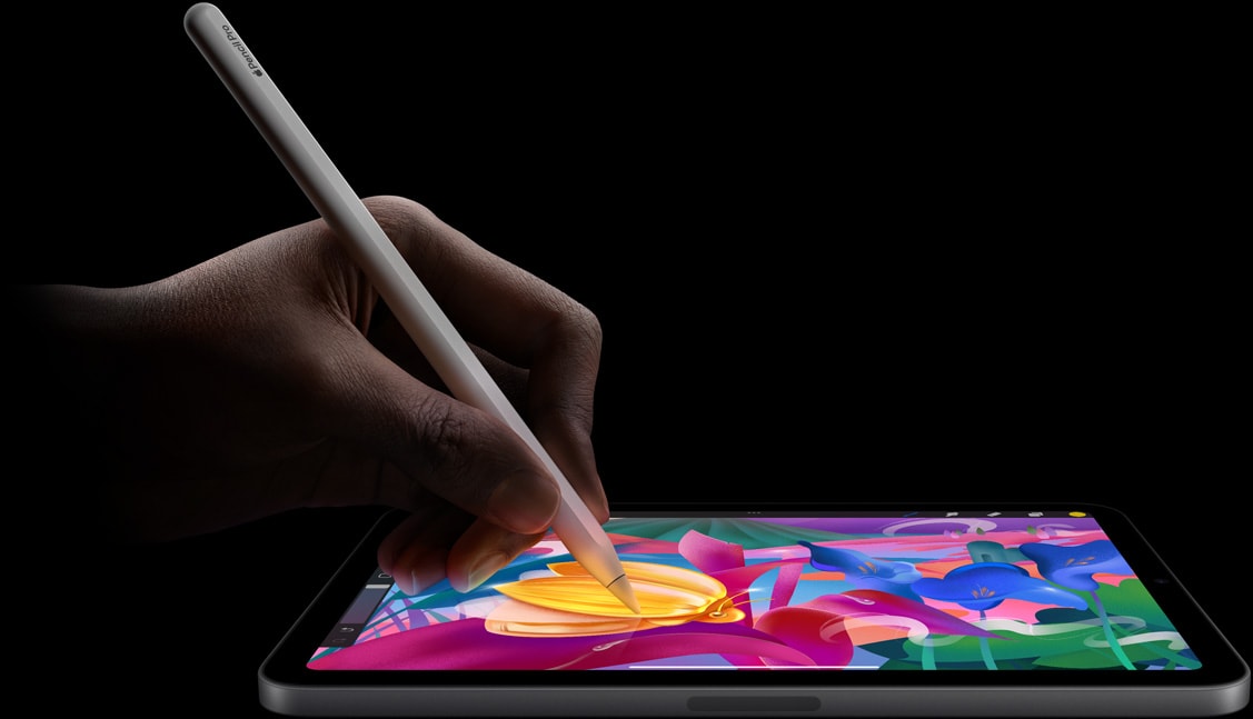 A user’s hand holding Apple Pencil Pro creating colorful artwork on iPad mini.