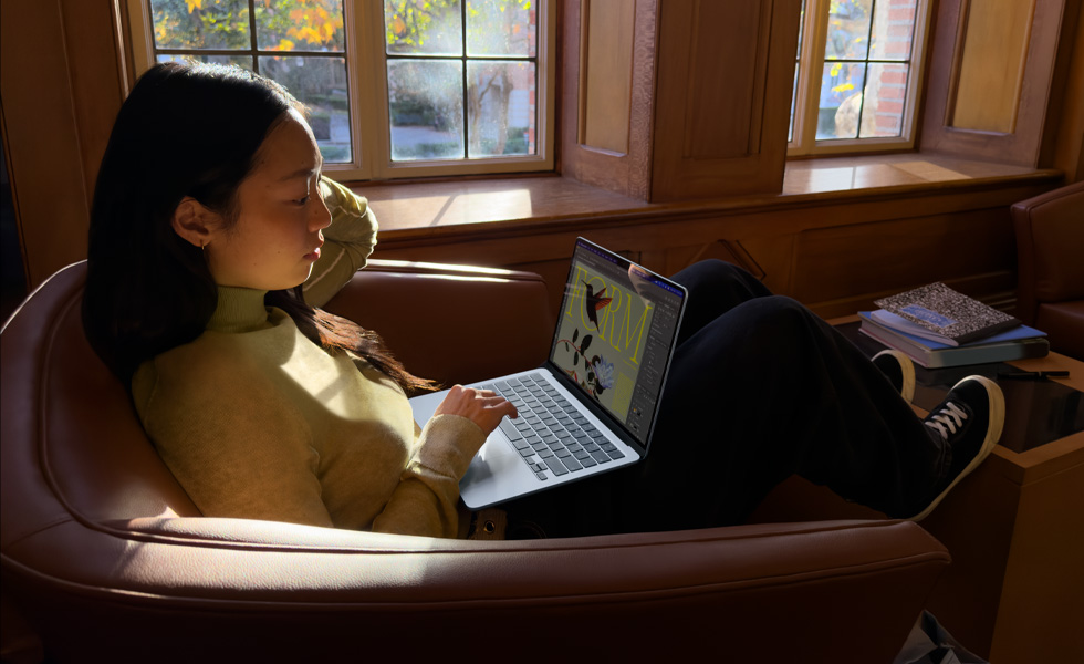의자에 앉아 MacBook Air를 사용 중인 사람의 모습