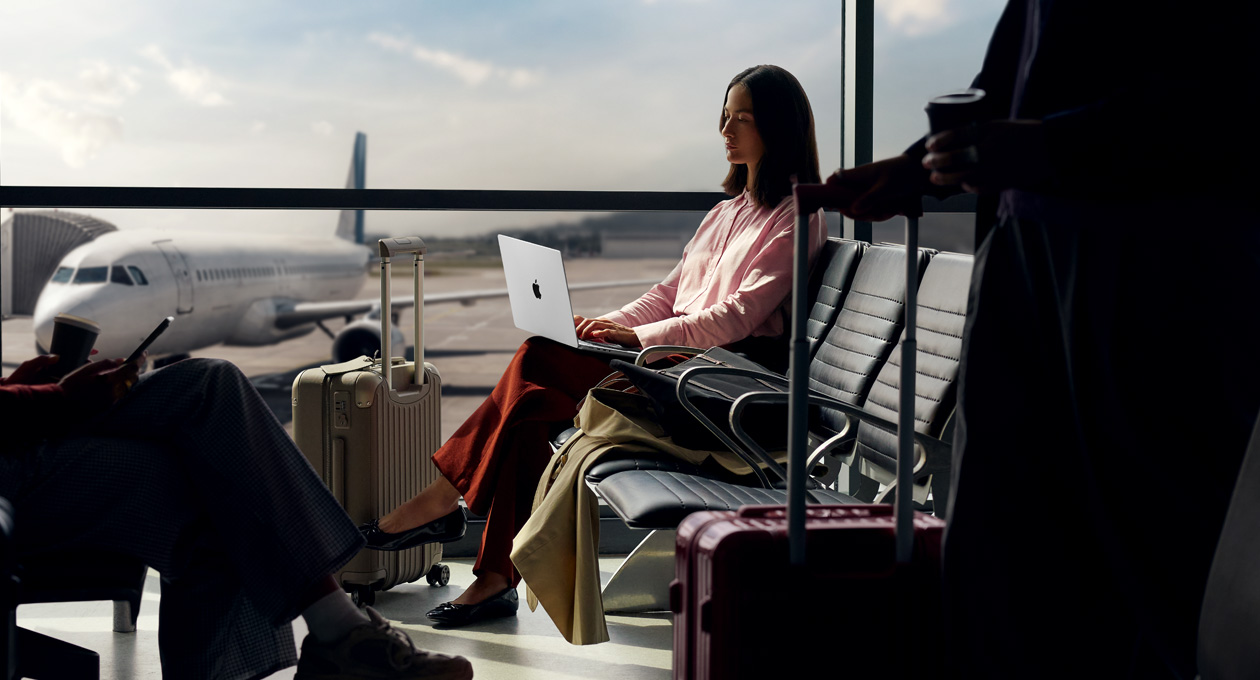 Une personne utilise son MacBook Pro dans un aéroport