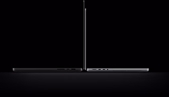 MacBook Pro com tela PROLED XDR de 14 polegadas prateado sobre um modelo de 16 polegadas, na cor preto-espacial, mostrando a diferença de tamanho