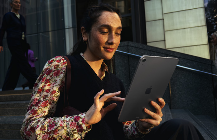 넓은 건물 밖에 앉아 스페이스 그레이 색상 iPad Air 11을 사용하는 사람의 모습. 네트워크 전송 전반에 걸쳐 매끄러운 Wi-Fi 연결이 유지됩니다.